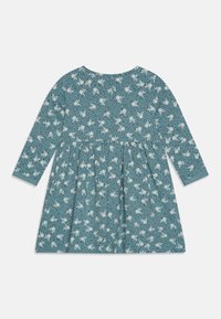 Dlouhý rukáv šaty v tyrkysové tkanině s rozptýleným bílým květinovým potiskem a černými tečkami, s nařaseným pasem a kulatým výstřihem.