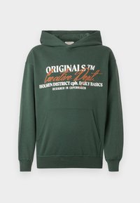 Σκούρο πράσινο μπουφάν φτιαγμένο από μείγμα βαμβακιού. Διαθέτει τσέπη καγκουρό, ριμπ μανσέτες και εκτυπωμένο κείμενο σε λευκό και πορτοκαλί χρώμα. Σχεδιασμένο στην Κοπεγχάγη.