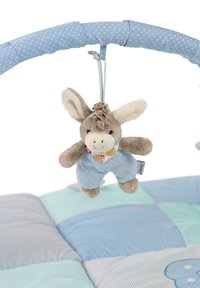 Weicher Plüsch-Esel in blauen Pünktchen-Latzhosen, mit einem gemusterten Schal, der von einem hellblauen, gepolsterten Bogen über einer gesteppte Matte hängt.