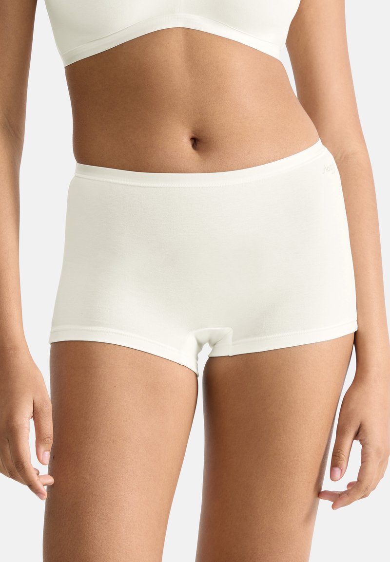 Shorts hipster blancs en coton avec une texture lisse et une taille élastique, présentant des coutures minimalistes et un design sans couture.