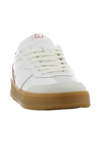 Witte sneaker met een gumrubberen zool, bovenwerk van suede en leer, vetersluiting en rode logodetail. Kenmerkt zich door een ronde neus en textuuraccenten.