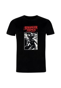 Camiseta negra con el texto rojo "Stranger Things" y un gráfico en blanco y negro del monstruo Demogorgon del programa en postura de combate.