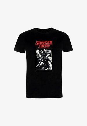 Sort T-shirt med rød "Stranger Things"-tekst og en sort-hvid grafik af seriens Demogorgon-monster i kampstilling.