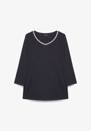 Top nero a maniche lunghe con scollo a V rifinito da piccole perline decorative bianche.