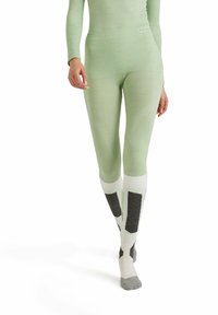 Light green leggings with a textured design, featuring white cuffs and dark gray accents at the lower leg. Soft fabric, form-fitting shape.