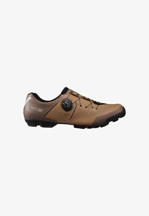 Zapatilla de ciclismo marrón con diseño perforado, suela negra y sistema de cierre con dial BOA en el lateral.