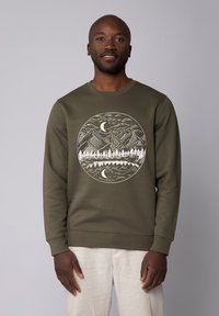 Olijfgroene sweatshirt met een ronde halslijn. Beschikt over een witte grafiek van bergen, bomen en een maan binnen een cirkelvormig ontwerp.