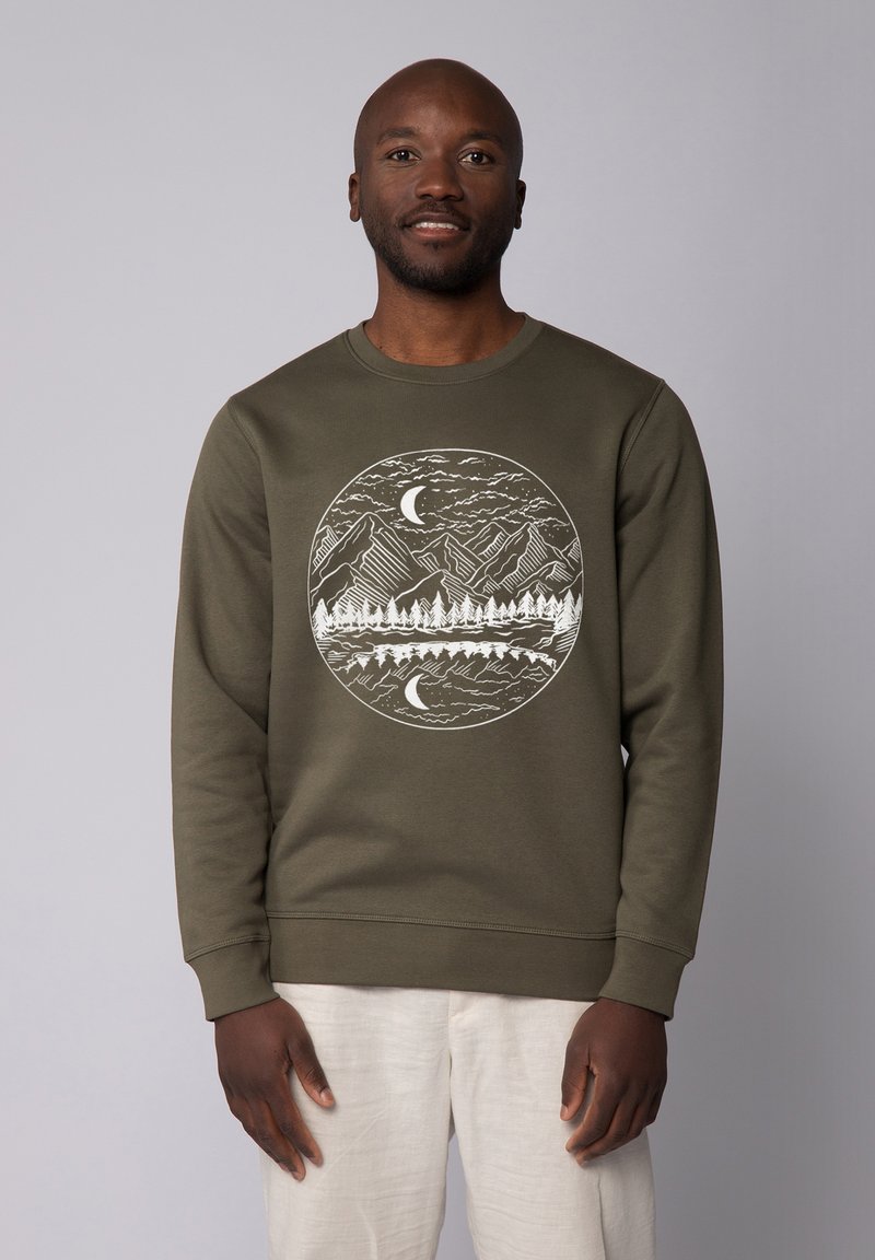 Olijfgroene sweatshirt met een ronde halslijn. Beschikt over een witte grafiek van bergen, bomen en een maan binnen een cirkelvormig ontwerp.