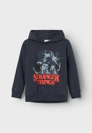 Sweat à capuche bleu foncé avec le logo Stranger Things en rouge, illustré de silhouettes d'enfants à vélo devant un grand fond de pleine lune.