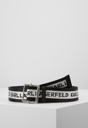 Czarnobiały tkany materiałowy pasek z napisem "KARL LAGERFELD" i prostokątną srebrną metalową klamrą na białej powierzchni.
