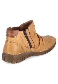 Brązowe skórzane botki za kostkę o teksturowanym, luźnym fasonie. Posiadają brązowy akcent na pięcie oraz boczny zamek błyskawiczny do zapięcia. Gumowa podeszwa.