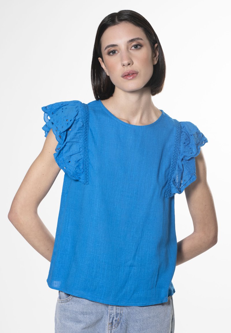 Top in lino blu con maniche in pizzo arricciato, scollo rotondo e vestibilità comoda. Design semplice con una texture sottile e un colore vivace.