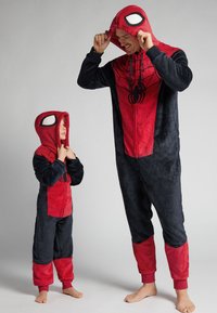 Monos de vellón rojo y negro con diseño de Spider-Man, con capuchas, emblema de araña y puños en contraste. Padre e hijo de pie.