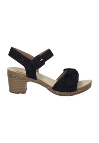 Sort ruskindsandal med en sløjfedetalje, justerbar ankelrem og en korkstruktureret mellemhøj hæl. Blød indvendig foring for komfort.