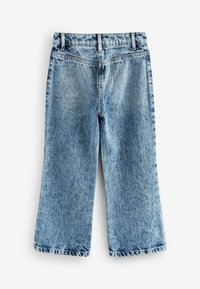Modré denimové culottes s vysokým pasem, širokými nohavicemi a minimálním vyblednutím. Obsahují tradiční design s pěti kapsami a poutky na opasek.