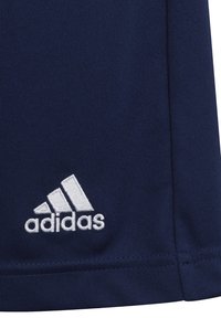 Tela deportiva en azul marino con superficie texturizada. Presenta un logotipo de Adidas bordado en blanco con tres franjas cerca del dobladillo.