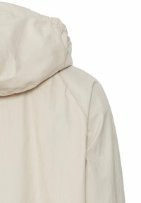 Helle beige Kapuzenjacke mit gerafft gestaltetem Kragen, glatter Textur und ohne sichtbare Verschlüsse; verfügt über ein schlichtes, minimalistisches Design.