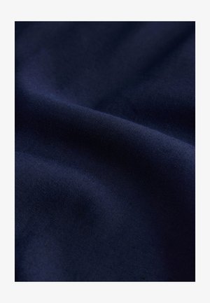 Navy blue fabric with a smooth, slightly shiny texture, showcasing gentle folds that enhance its depth and richness.