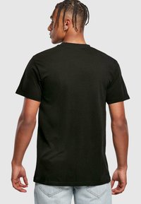 Zwarte katoenen T-shirt met een ronde hals en korte mouwen, met een effen ontwerp. Zichtbare achterkantnaad en een soepele textuur.