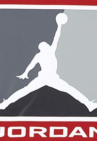 Logo bianco di una figura che salta tenendo un pallone da basket, su uno sfondo grigio e nero con accenti rossi e il testo in grassetto "JORDAN".