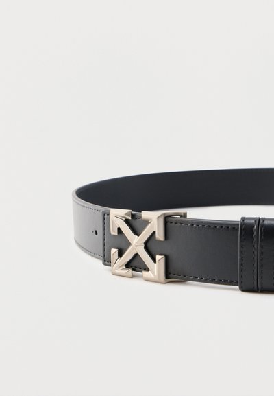 Μαύρη δερμάτινη ζώνη με ασημένια αγκράφα σε σχήμα τεσσάρων βελών που δείχνουν προς τα έξω σχηματίζοντας ένα σταυρό.