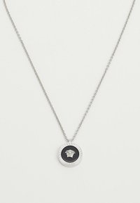 Sudraba ķēdes kaklarota ar apaļu melnu kulonu, kurā attēlots sudraba Medūzas galva un Grieķu taustiņa apmale.