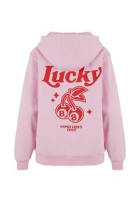 Sudadera rosa con capucha. Gráfico rojo en la parte posterior que presenta "Lucky", diseño de cereza, "88" y el texto "SOLO BUENAS VIBRACIONES". Textura de tela suave.