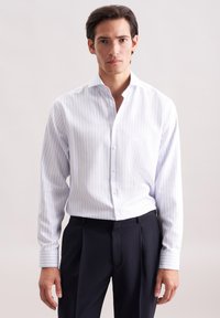 Camicia bianca a righe con colletto a punta, chiusura a bottoni e maniche lunghe. Il tessuto appare liscio e leggero, con una texture sottile.