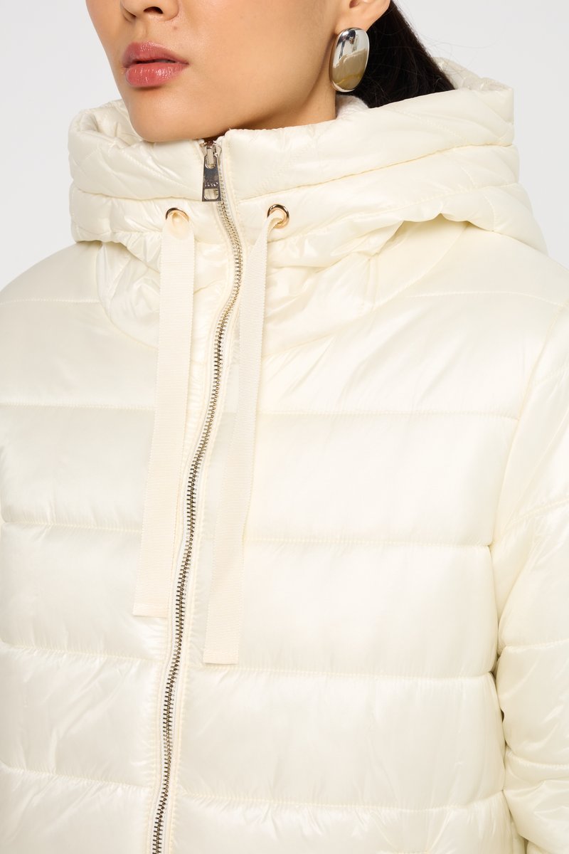 Giacca a vento in bianco sporco, con colletto alto, chiusura frontale con zip e texture satinata con cuciture orizzontali sottili.