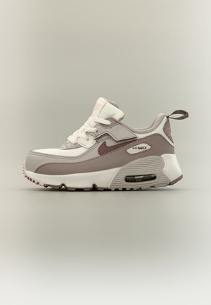 Χαμηλού ύψους αθλητικό παπούτσι Nike Air Max σε λευκό και ταουπέ, με ορατή αερόσολα και θηλιά στην πτέρνα, εμφανιζόμενο σε πλευρική προβολή.