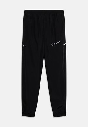 Black athletic pants with elastic waistband, tapered legs, side pockets, and white Nike swoosh logo; made of smooth, lightweight fabric.