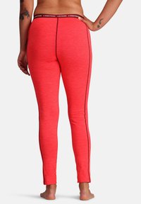Rote Sportleggings aus strukturiertem Stoff mit einem kontrastierenden schwarzen Seitenstreifen und einem Logo-Gummibund. Figurbetontes Design mit glatter Oberfläche.