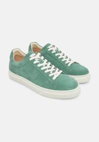Sneakers in suede verde con lacci bianchi, punta rotonda e suola in gomma crema. Texture liscia con design minimalista e dettagli di cucitura sottili.