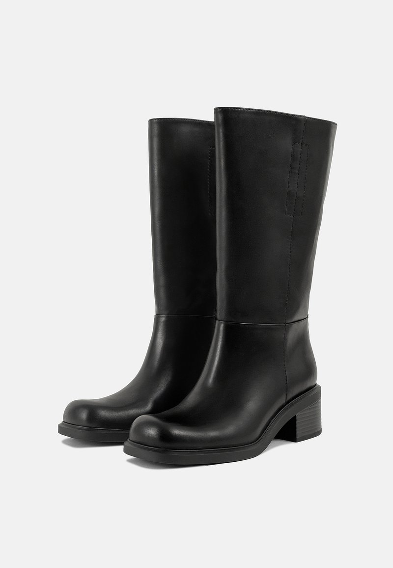 Stivali neri in pelle alti fino al ginocchio, con punta tonda, tacco a blocco e cuciture minime. Texture liscia con accenti sui pannelli laterali.