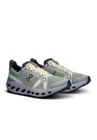 Lightweight running shoes featuring a grey mesh upper with lavender accents, a cushioned sole, and a unique cut-out design on the outsole.