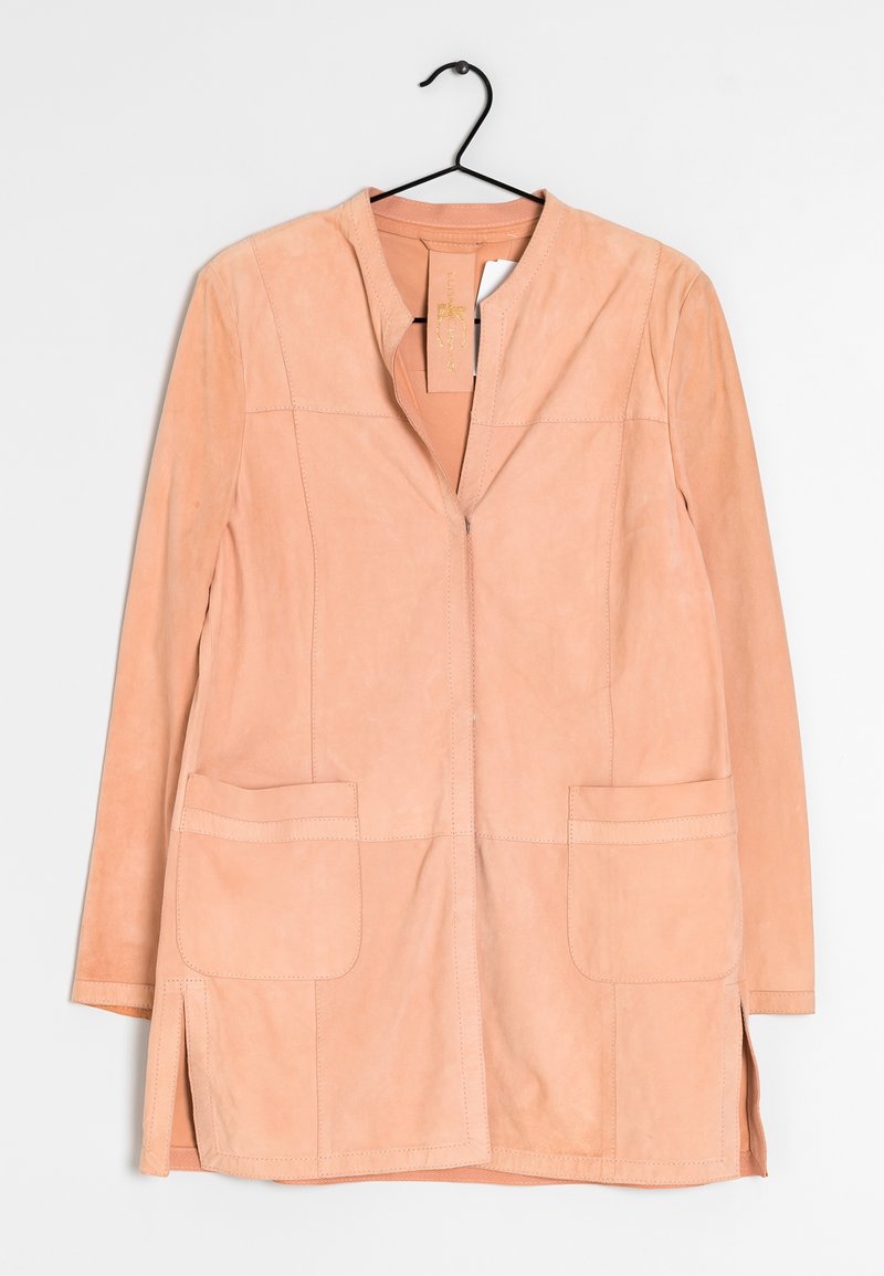 Persikofärgad mockajacka med notchkrage, framdragkedja och två stora framfickor. Har sidofickor och stickningsdetaljer.