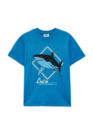 Maglietta blu a maniche corte per bambini con una grande grafica di uno squalo all'interno di una forma a rombo e la scritta "Lost in Adventures 1984" sul davanti.