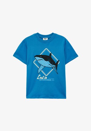 Blauw kindershirt met korte mouwen, met een grote haai in een diamanten vorm en de tekst "Lost in Adventures 1984" aan de voorkant.