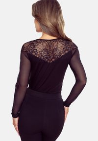 Czarny bodysuit z długimi przezroczystymi rękawami i koronkowym wzorem na plecach z motywami kwiatowymi, uzupełniony gładką tkaniną i dopasowanym krojem.