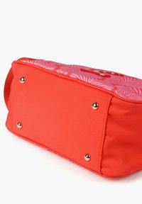 Bolso de tela roja con parte superior estampada y acentos de hardware dorado. Presenta una base plana y bordes redondeados para estabilidad y estilo.