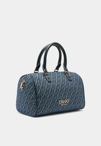 Blaue Handtasche mit Muster, dunkelblaue Lederhenkel, Reißverschluss und goldenen Beschlägen. Besitzt ein Logo auf der Vorderseite.