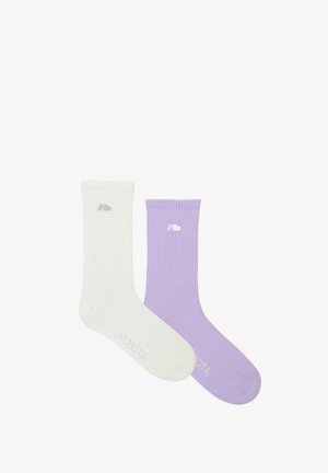 Dwie pary skarpetek żebrowych: jedne białe z jasnofioletowym logo, drugie lawendowe z białym logo. Obie mają standardową długość do kostki.