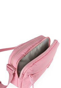 Bolsa cruzada acolchada de color rosa con doble cremallera. Presenta un interior suave y brillante de color gris claro y una pestaña tejida en el costado.