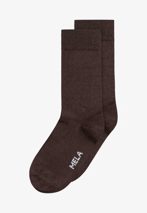 Pair of dark brown crew socks with ribbed cuffs and "MELA" written in white on the foot area.