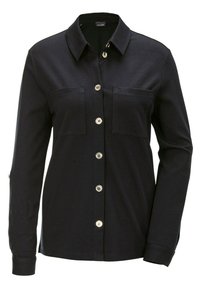 Schwarze Hemdbluse mit zwei Brusttaschen, langen Ärmeln, Kragen und silbernen Knöpfen zum Schließen. Aus einem glatten Stoff gefertigt.