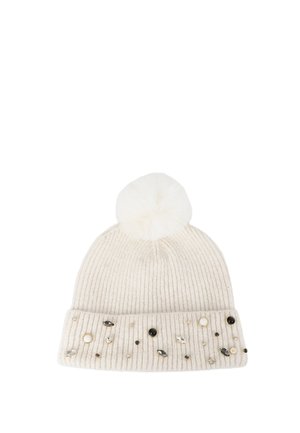 Gorro de punto acanalado de color crema con un pompón blanco en la parte superior y adornado con piedras decorativas negras, doradas y transparentes en el puño.