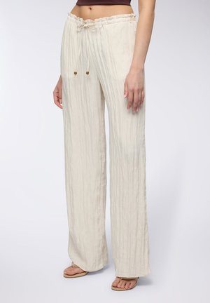 Pantaloni leggeri color crema a gamba larga con superficie testurizzata, vita elastica e dettagli con lacci dotati di elementi in legno.