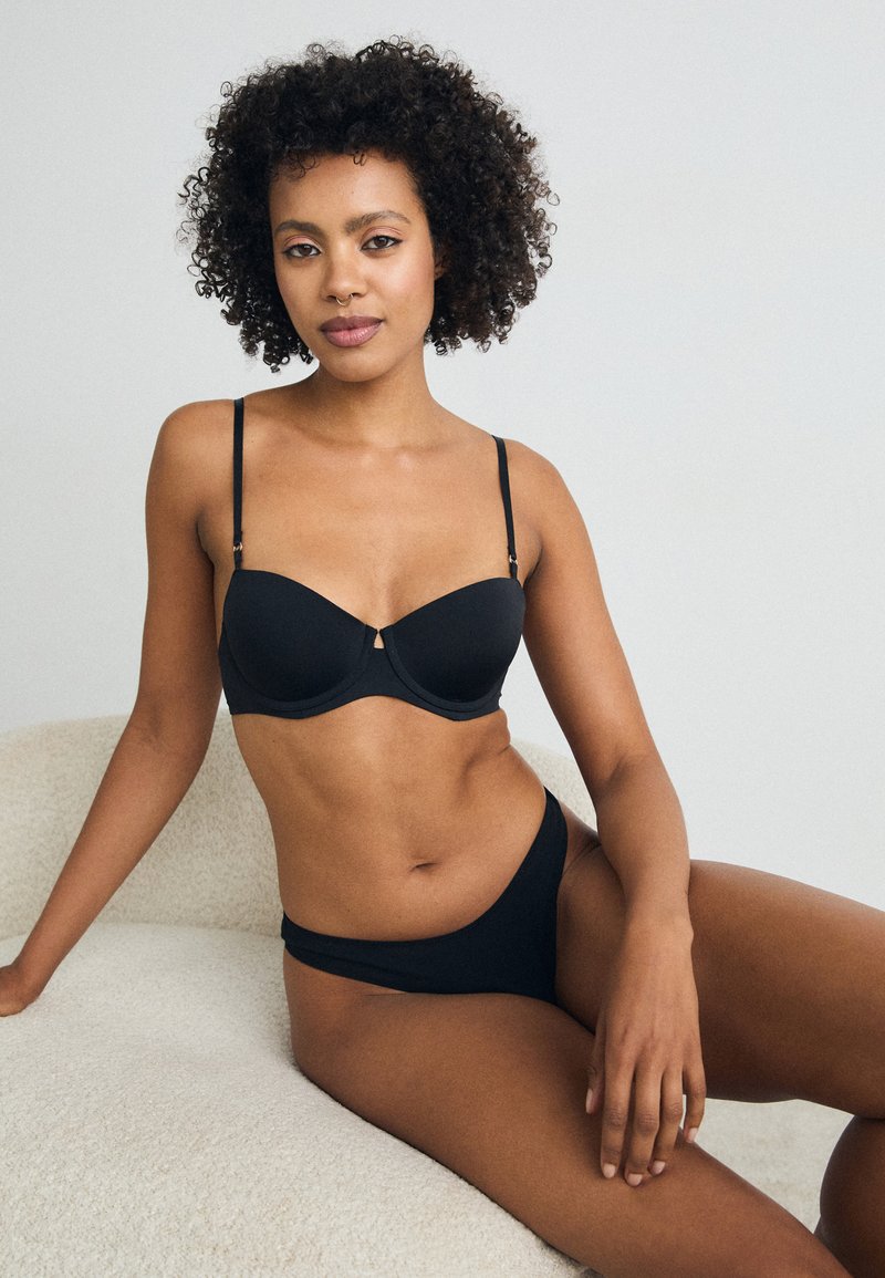 Black bra and matching brief set with smooth fabric, underwire support, adjustable straps, and minimalistic design.
