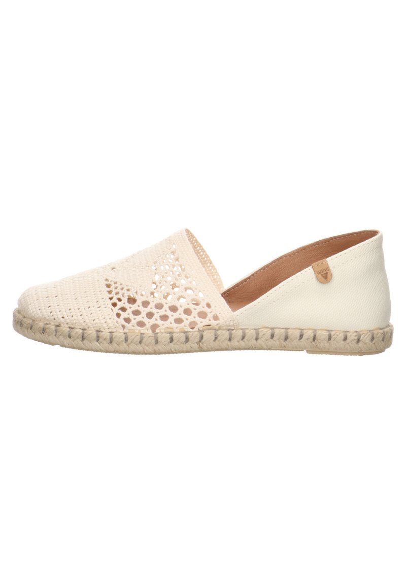 Zapato slip-on de esparto de color beige claro con parte superior de tejido trenzado que presenta detalles con recortes, suela de fibra natural y costuras decorativas a lo largo del borde.