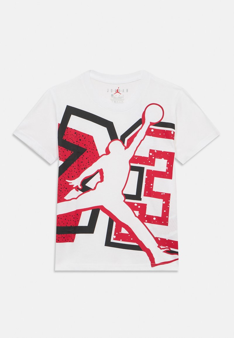 Άσπρο βαμβακερό t-shirt με κόκκινο και μαύρο γραφικό που απεικονίζει έναν παίκτη μπάσκετ σε άλμα, με έντονες μορφές και φόντο με πουά.